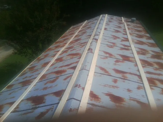 Rusted metal roof panels with new wood purlins before replacement — Storm Damage Roof Repair in Ludowici by Roofing Brothers