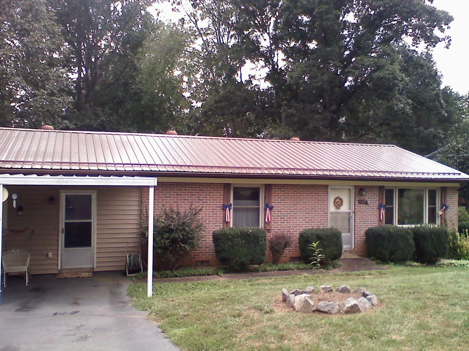 Bronze metal roof and carport on a brick ranch home — Roof Repair work by our crew in Ludowici