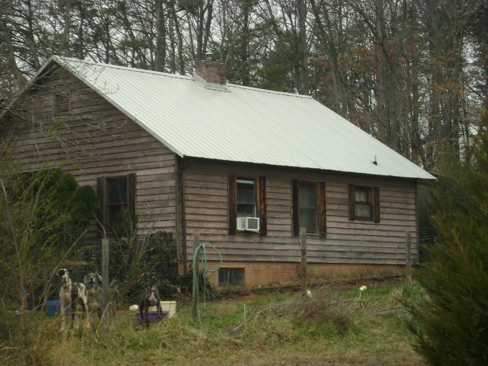 White metal roof on an old wood sided farmhouse, from a Metal Roof Installation job in Ludowici